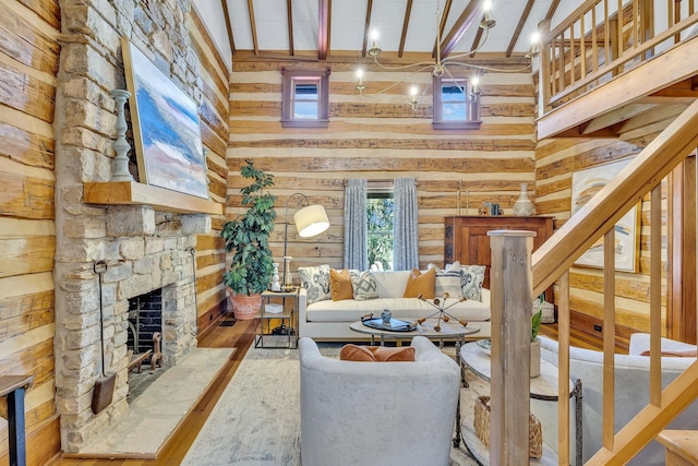 living room featuring hardwood / wood-style flooring, a stone fireplace, a high ceiling, and beamed ceiling