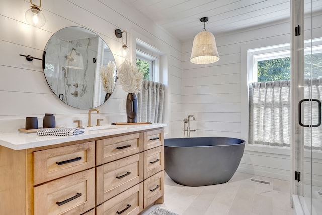 bathroom with a wealth of natural light, independent shower and bath, and tile flooring