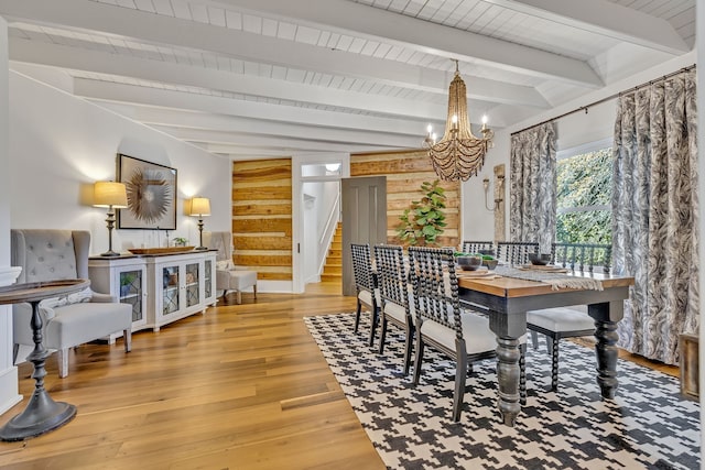 dining room with beamed ceiling, wood-type flooring, and a chandelier