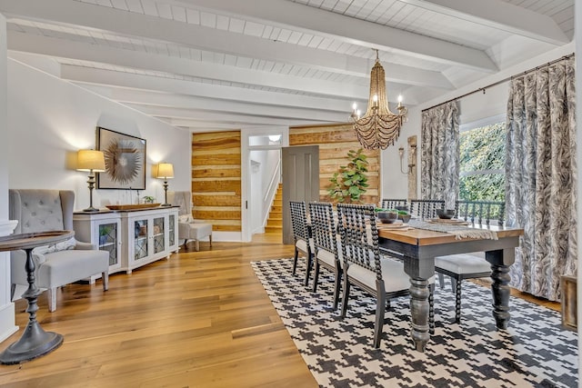 dining space with beamed ceiling, hardwood / wood-style floors, wood ceiling, and a chandelier