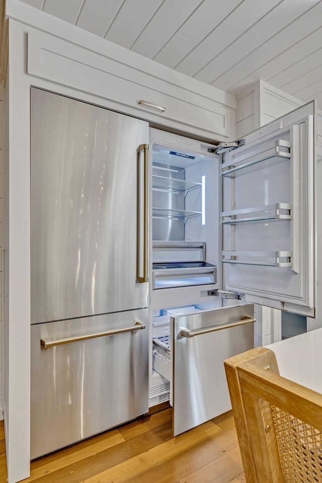 kitchen featuring white cabinets, high end fridge, and light hardwood / wood-style flooring