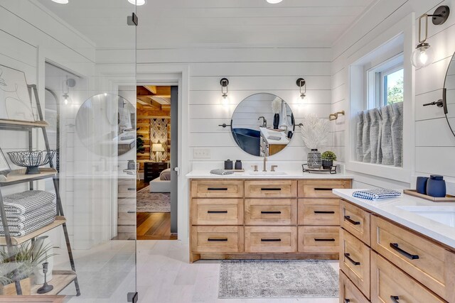 bathroom featuring wood-type flooring, wooden walls, and vanity