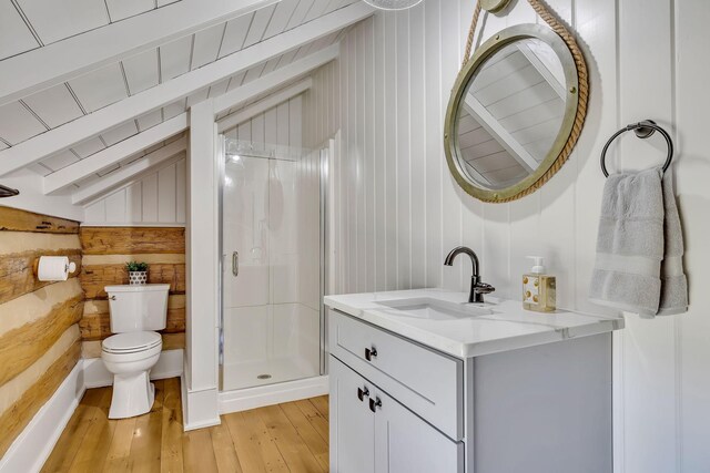 bathroom featuring oversized vanity, toilet, a shower with door, wood-type flooring, and lofted ceiling with beams