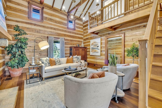 living room with hardwood / wood-style flooring, wooden walls, and a towering ceiling