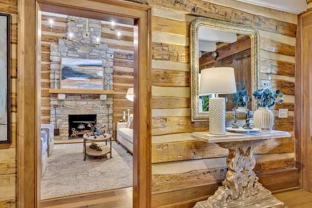 stairs featuring a stone fireplace and wood-type flooring