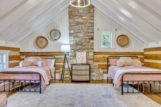 bedroom with lofted ceiling with beams and hardwood / wood-style flooring