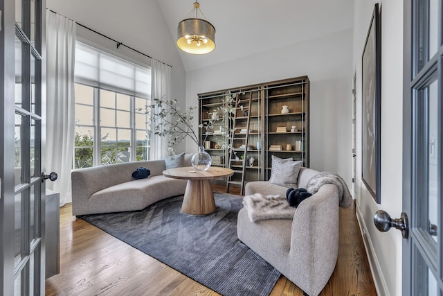 sitting room with french doors, hardwood / wood-style floors, and lofted ceiling