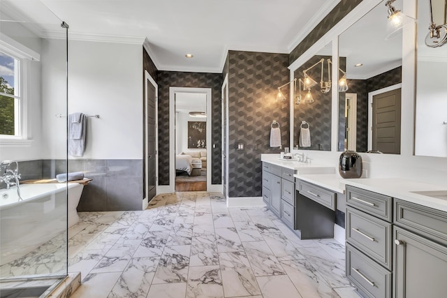 bathroom with a washtub, vanity, and ornamental molding