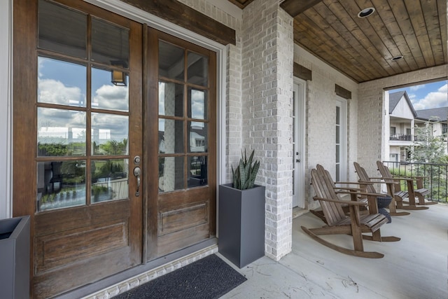 entrance to property with french doors and a porch