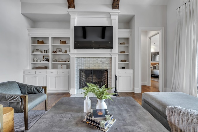 living room featuring a tiled fireplace and dark hardwood / wood-style flooring