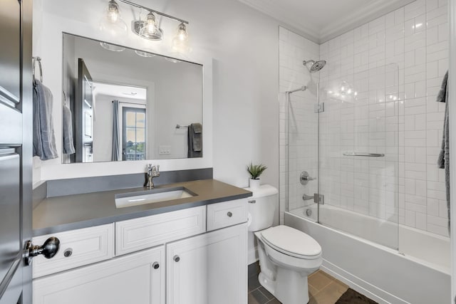 full bathroom featuring crown molding, toilet, vanity, and tiled shower / bath