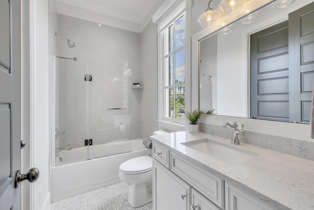 full bathroom with tile patterned floors, ornamental molding, bath / shower combo with glass door, vanity, and toilet