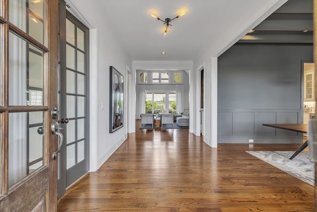 foyer entrance featuring crown molding and dark hardwood / wood-style floors