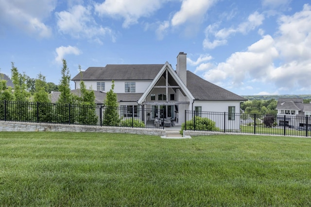 back of house featuring a lawn and a patio area