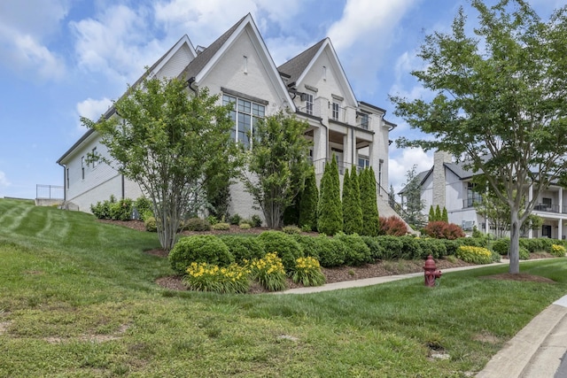 view of home's exterior featuring a yard and a balcony