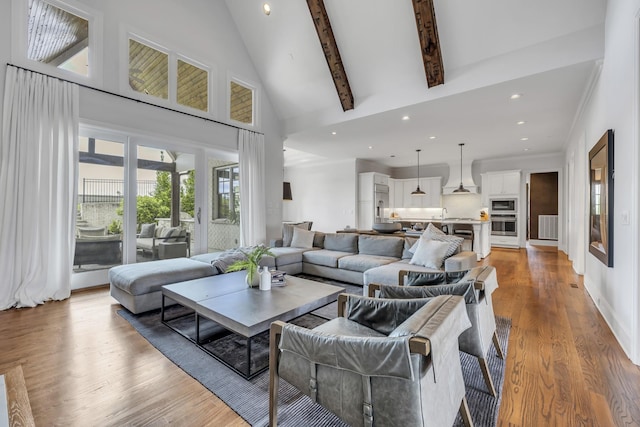 living room with hardwood / wood-style flooring, beamed ceiling, and high vaulted ceiling