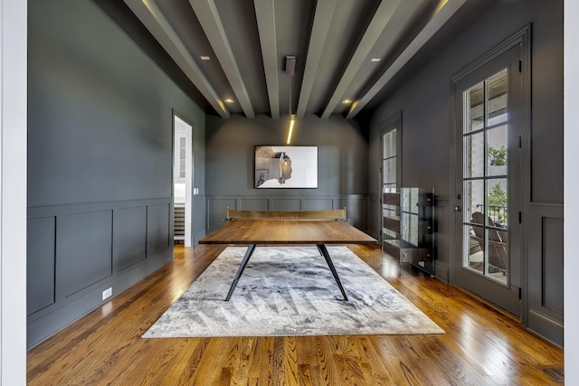 unfurnished office with beamed ceiling and wood-type flooring