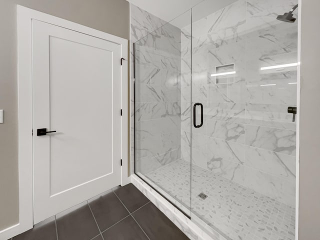 bathroom with tile patterned floors and a shower with door