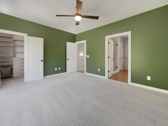 unfurnished bedroom with ceiling fan, ensuite bath, light carpet, and a closet