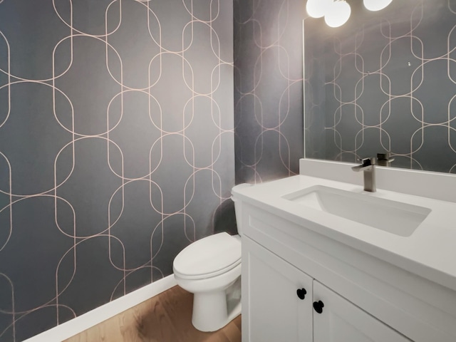 bathroom featuring wood-type flooring, vanity, and toilet