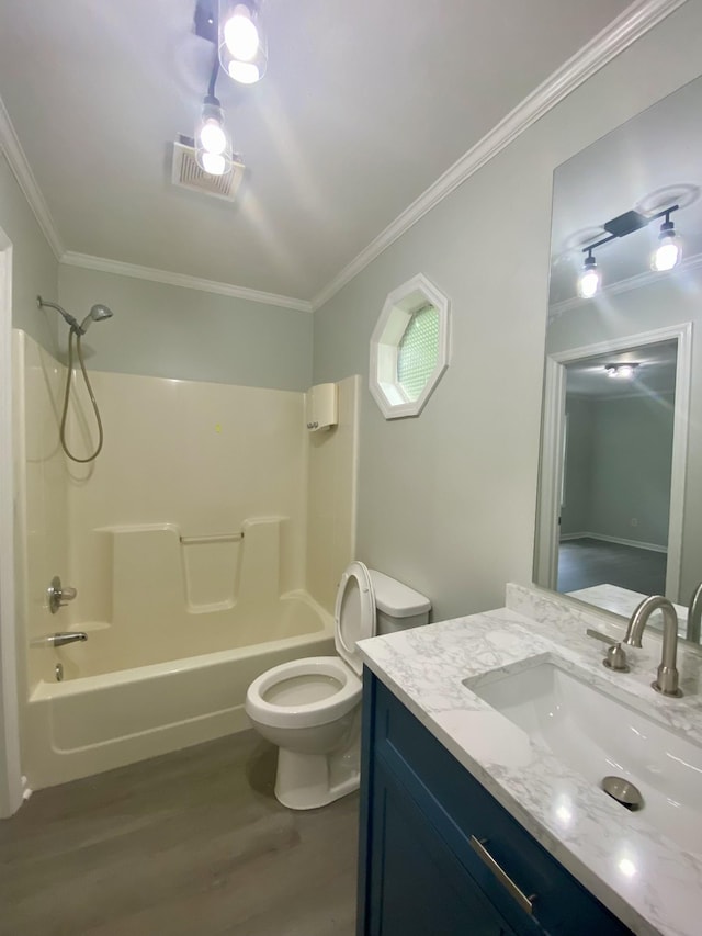 full bathroom featuring hardwood / wood-style floors, vanity, ornamental molding, and bathing tub / shower combination