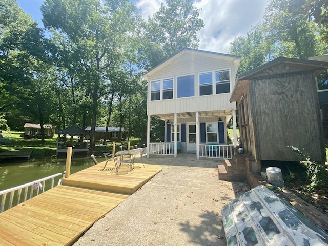 back of property featuring a water view and a storage shed