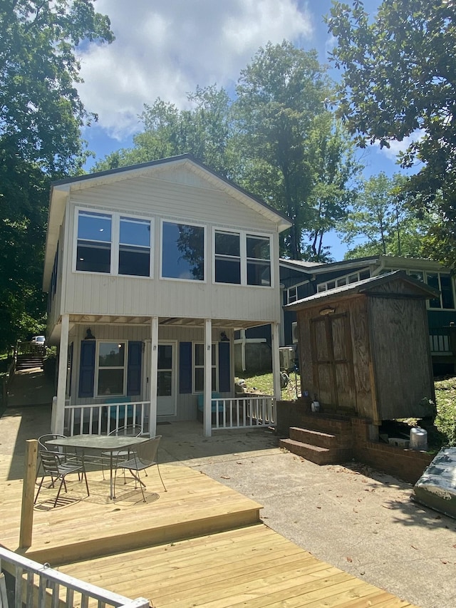 back of property featuring a porch, a shed, and a deck