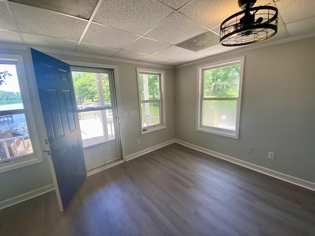 interior space with a paneled ceiling, crown molding, and dark wood-type flooring