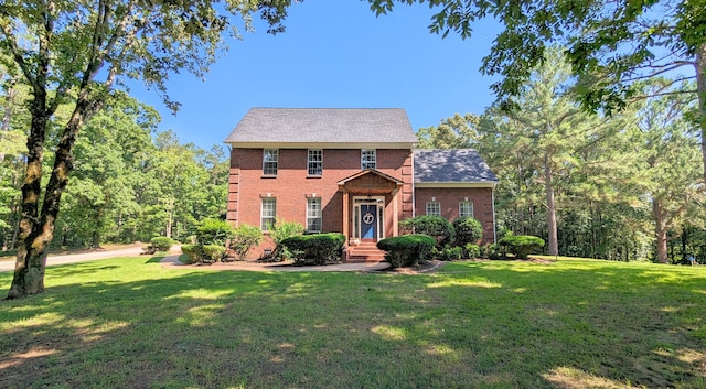 colonial-style house featuring a front yard