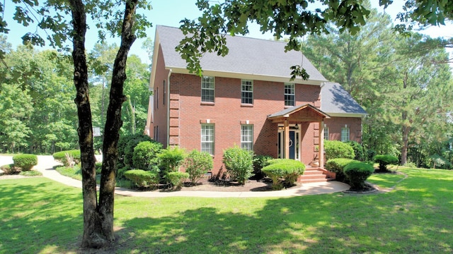 colonial-style house featuring a front yard