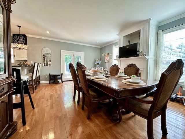 dining room with french doors, ornamental molding, and light hardwood / wood-style flooring