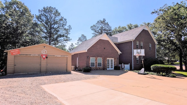 view of front facade with a garage, an outdoor structure, and french doors