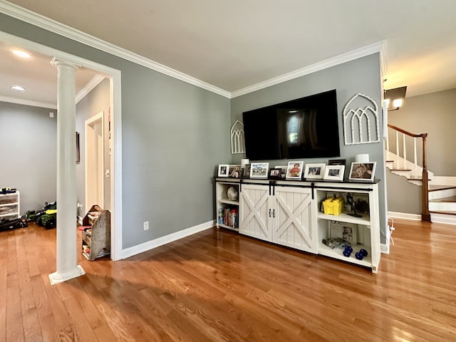 living room with wood-type flooring, ornate columns, and crown molding