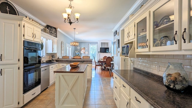 kitchen featuring a center island, crown molding, stainless steel appliances, pendant lighting, and tasteful backsplash