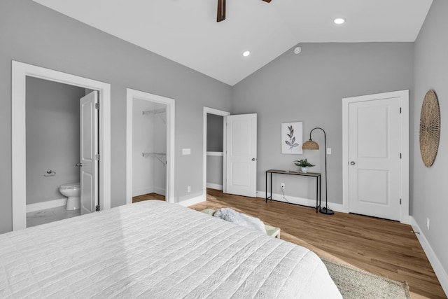 bedroom with connected bathroom, lofted ceiling, a walk in closet, light wood-type flooring, and ceiling fan