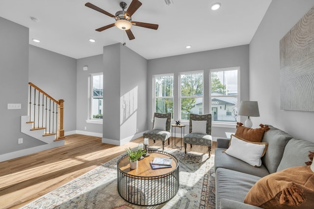 living room with light hardwood / wood-style flooring and ceiling fan