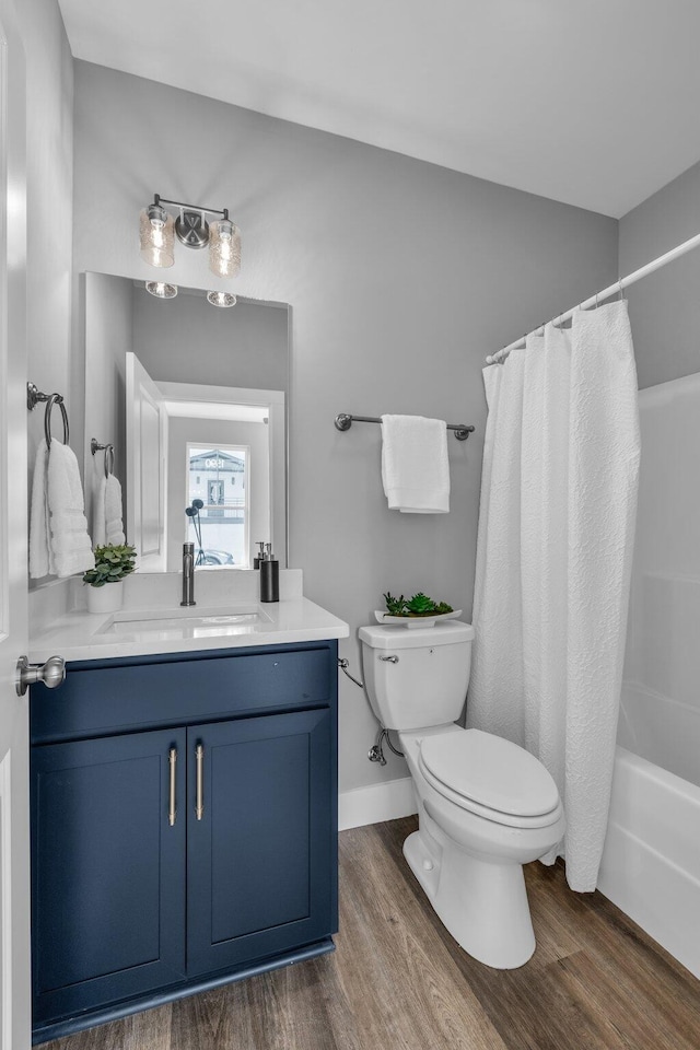 full bathroom featuring vanity, wood-type flooring, toilet, and shower / bathtub combination with curtain