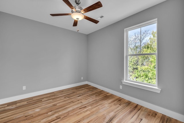 spare room featuring a healthy amount of sunlight, light wood-type flooring, and ceiling fan