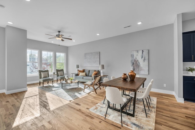 dining space with ceiling fan and light hardwood / wood-style flooring