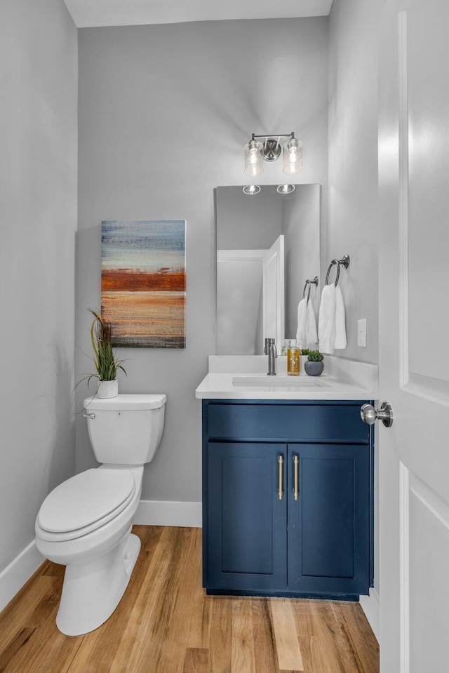 bathroom featuring vanity, hardwood / wood-style flooring, and toilet