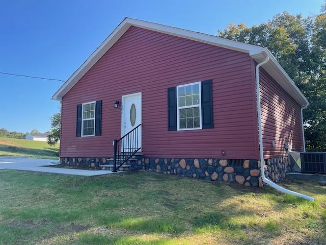 view of front of home featuring a front lawn, entry steps, and central AC unit