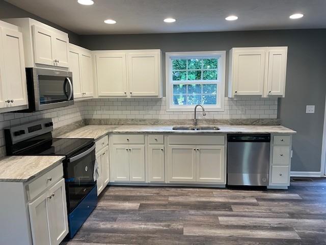 kitchen featuring white cabinetry, stainless steel appliances, and a sink