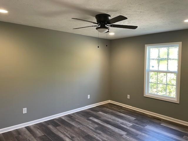 unfurnished room featuring recessed lighting, a ceiling fan, dark wood-style floors, and baseboards