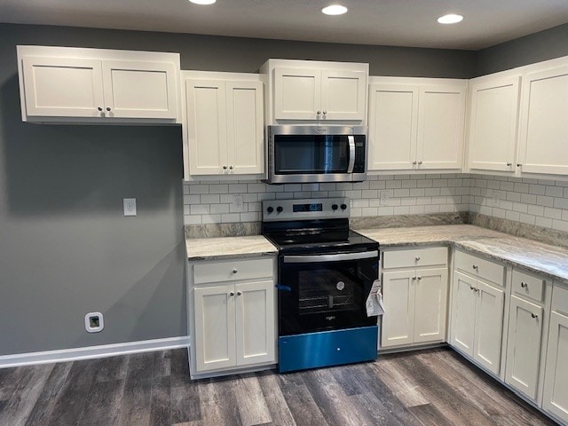 kitchen featuring tasteful backsplash, stainless steel appliances, white cabinetry, and dark hardwood / wood-style floors