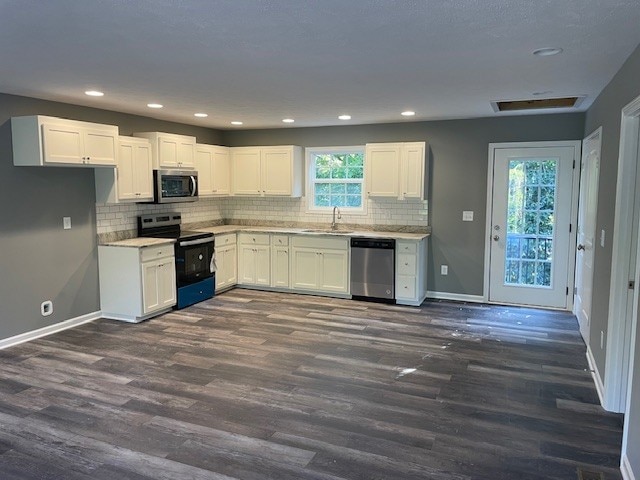 kitchen with white cabinets, sink, dark wood-type flooring, and appliances with stainless steel finishes