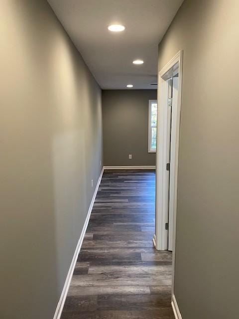 corridor featuring dark wood-style flooring, recessed lighting, and baseboards