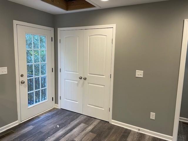 doorway with visible vents, dark wood-style flooring, and baseboards