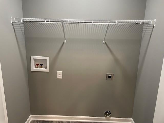 clothes washing area with hookup for an electric dryer, washer hookup, laundry area, and baseboards