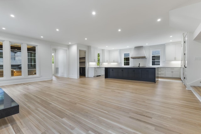 unfurnished living room featuring sink and light wood-type flooring