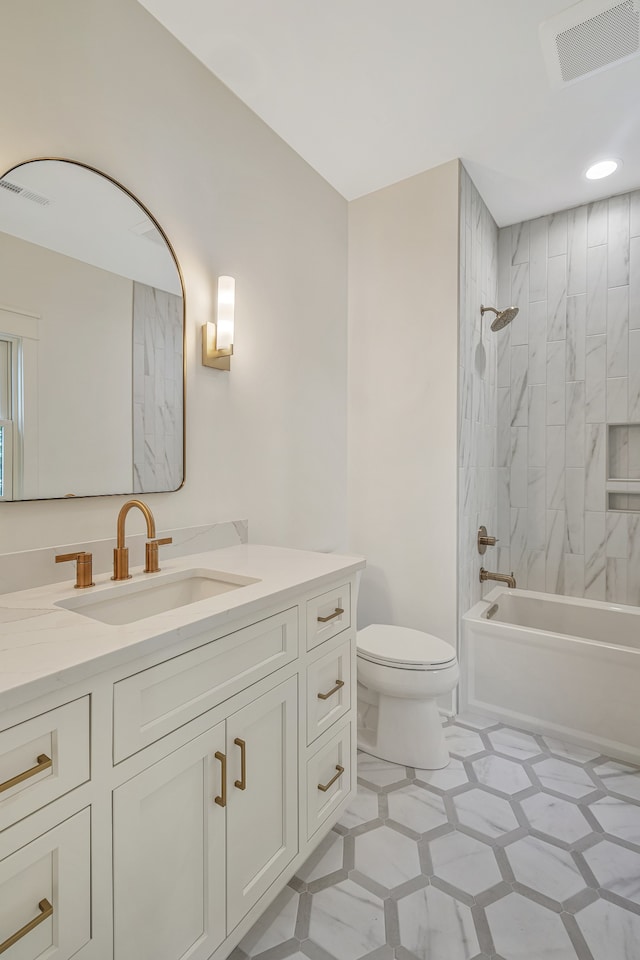 full bathroom with vanity, tiled shower / bath combo, and toilet